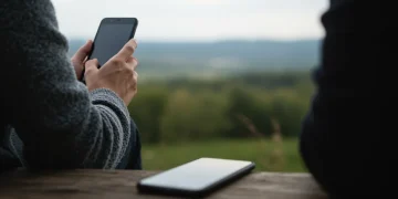 Person enjoying nature, putting down smartphone for digital detox