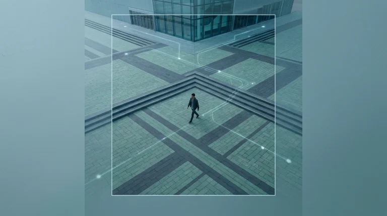 Aerial view of a person walking on a geometrically patterned urban plaza at dawn, symbolizing ambient computing and integrated digital living.